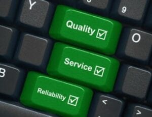 keyboard in green reading Quality service reliability