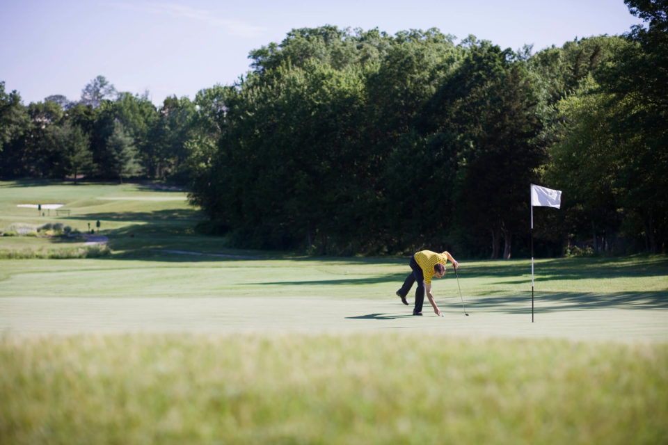 man on green of golf course