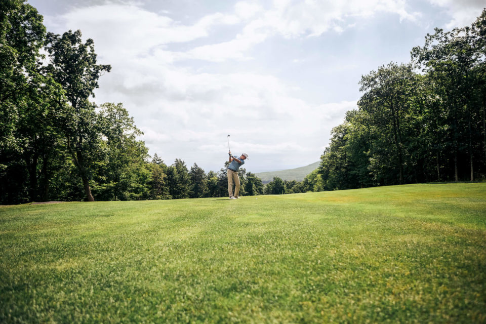 man hitting golf ball